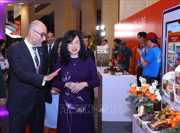 Minister of Health Dao Hong Lan (R) and Canadian Ambassador Shawn Steil at the exhibition held as part of the celebration event. (Photo: VNA)