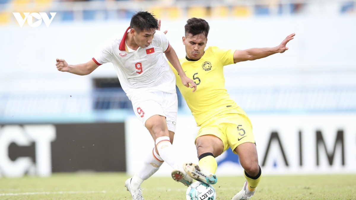 Fighting for the ball between a Vietnamese player (in white jersey) and a Malaysian player