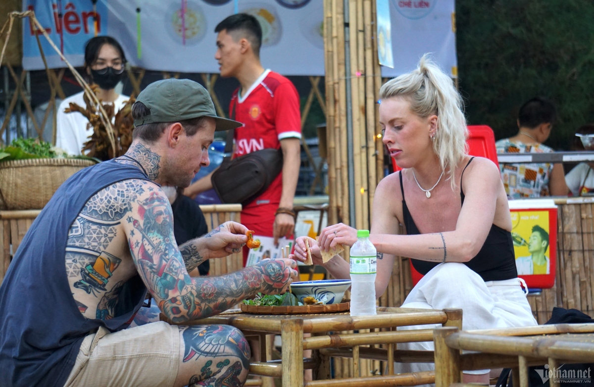 A foreign couple enjoy sampling Quang noodles (Mì Quảng) which originate from the central province of Quang Nam. The main ingredients include rice noodles, meat, and herbs.