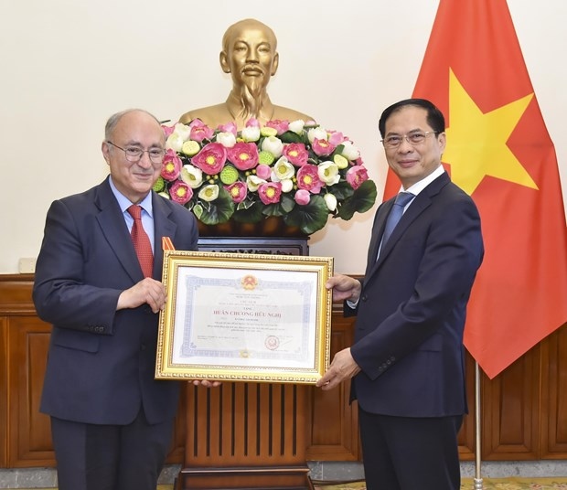 Minister of Foreign Affairs Bui Thanh Son (R) presents the Vietnamese State's Friendship Order to President of the World University Services (WUS) Germany Kambiz Ghawami in Hanoi on August 3. (Photo: VNA)