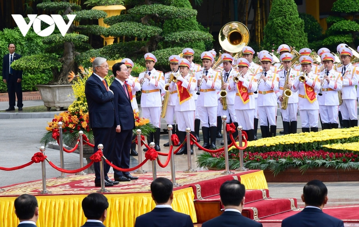 President Vo Van Thuong invites Kazakh President Kassym-Jomart Tokayev to step on the podium as military bands play the national anthems of both nations.