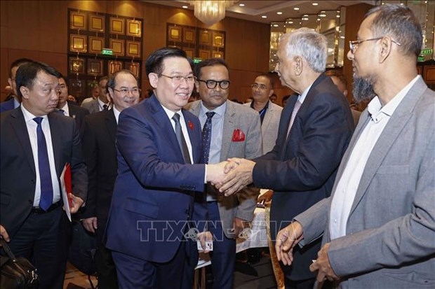 Chairman of the Vietnamese National Assembly Vuong Dinh Hue (second, left) and delegates attend the forum.