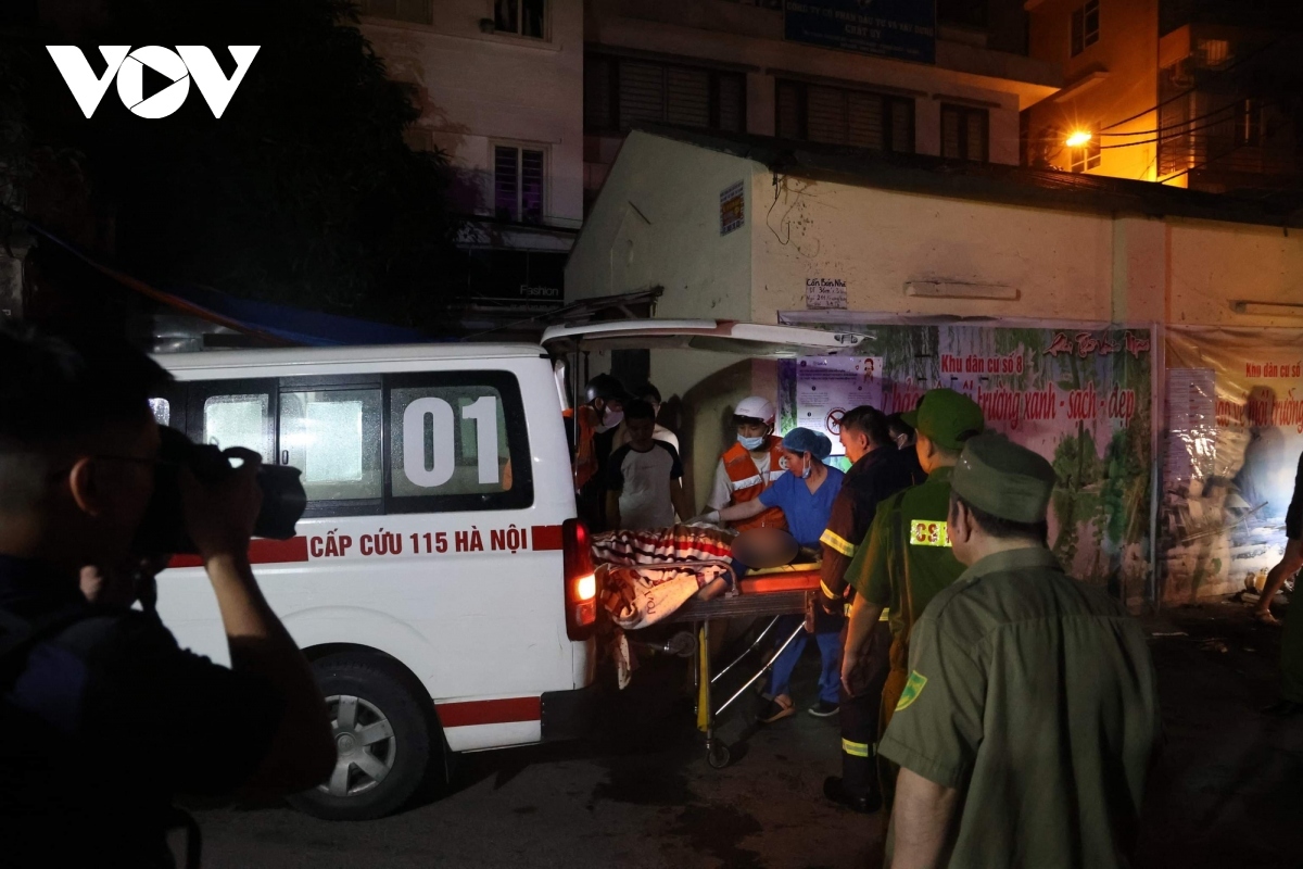 Medical staff transport a fire victim out of the burnt apartment building in Hanoi's Thanh Xuan District