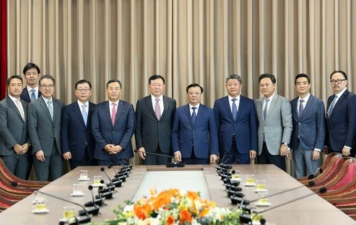 Secretary of Hanoi Party Committee Dinh Tien Dung (fifth from right) takes a photo with Lotte Group's representatives