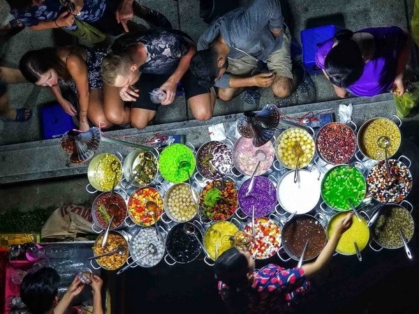 Foreign visitors enjoy "che Hue" (Hue sweentened porridge) at a street stall.