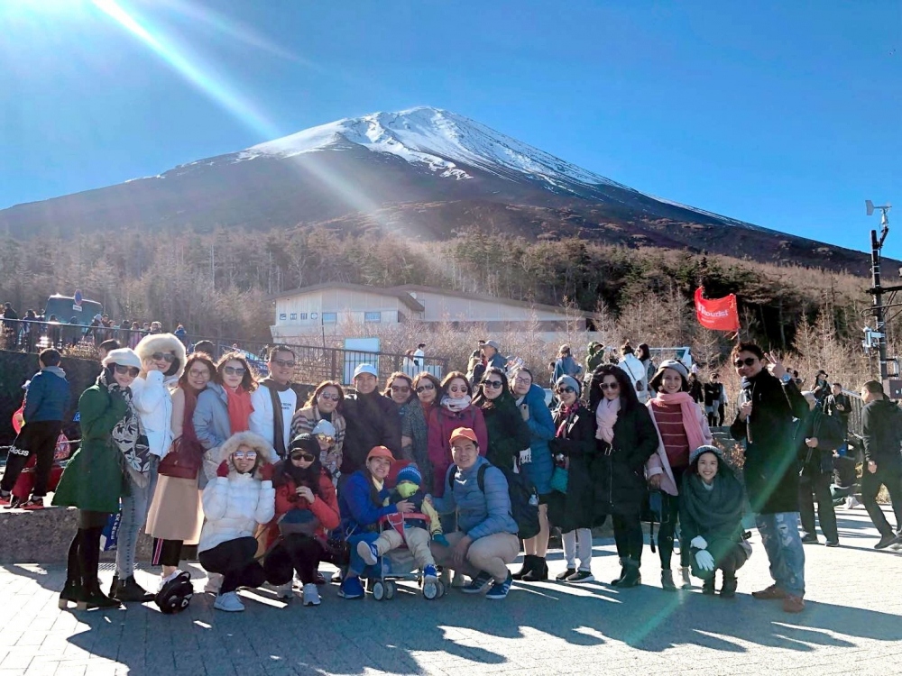 A group of Vietnamese tourists pose for a photo in front of Mount Fuji mountain in Japan (Photo: phunuonline.com.vn)