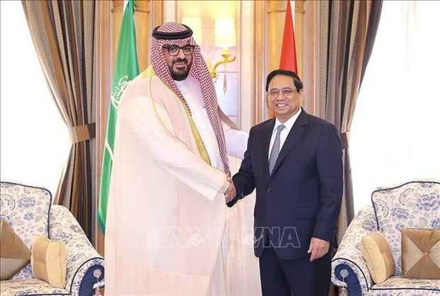 Prime Minister Pham Minh Chinh (R) and Saudi Arabia's Minister of Economy and Planning Faisal Al-Ibrahim (Photo: VNA) 