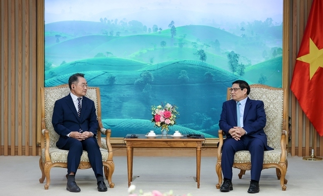 Vietnamese Prime Minister Pham Minh Chinh R) and vice president and CEO of Amkor Technology Inc,Ji Rong Rip, during their meeting in Hanoi on October 12. (Photo: VGP)