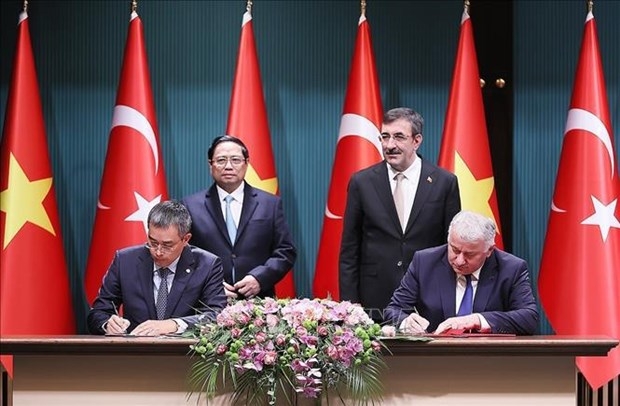 Prime Minister Pham Minh Chinh (left, second row) and Turkish Vice President Cevdet Yilmaz witness the signing of a Letter of Intent on cooperation between Vietnam Airlines and Turkish Airlines.