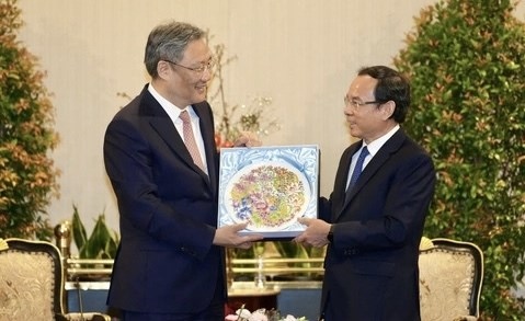 Chinese Minister of Commerce Wang Wentao (left) gives a present to Secretary of the Ho Chi Minh City Party Committee Nguyen Van Nen. (Photo: VNA)