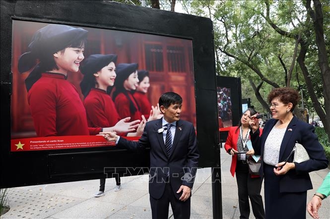 Vietnamese Ambassador to Mexico Nguyen Hoanh Nam introduces visitors to photos featuring beauty of Vietnamese people