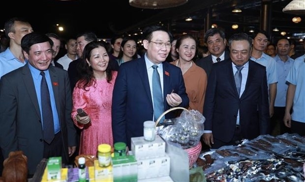 NA Chairman Vuong Dinh Hue (centre) visits booths display OCOP products at the Vietnam Craft Villages Festival.