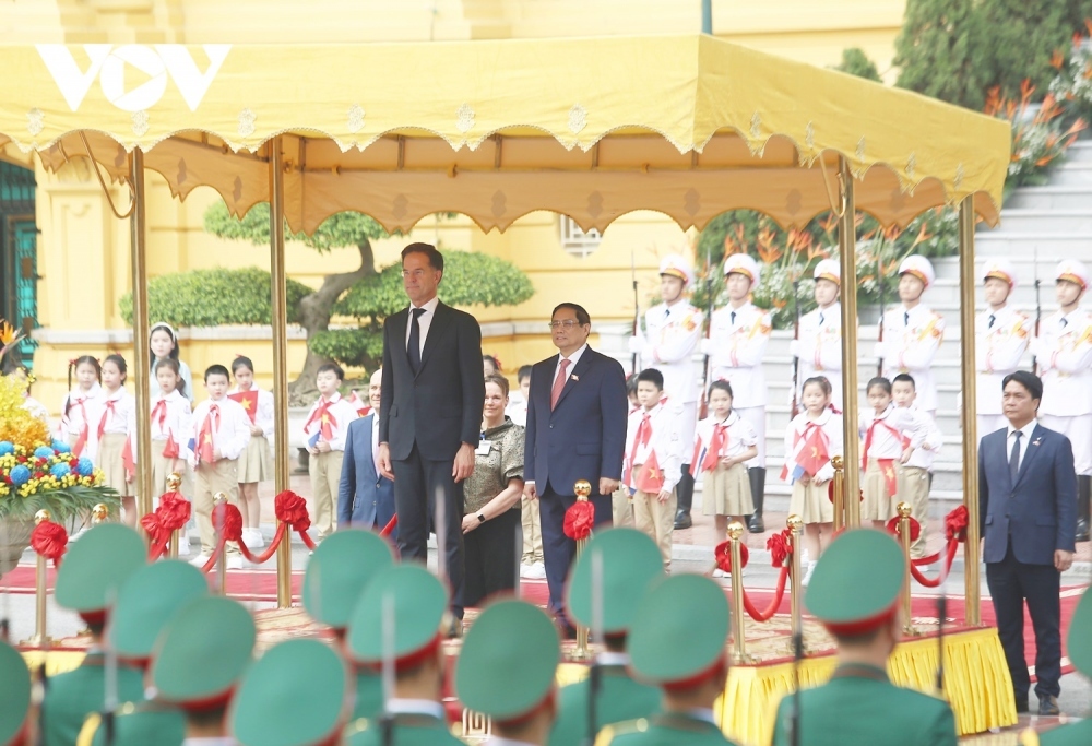 PM Chinh invites his Dutch counterpart to step on the podium while military bands play the national anthems of both nations.