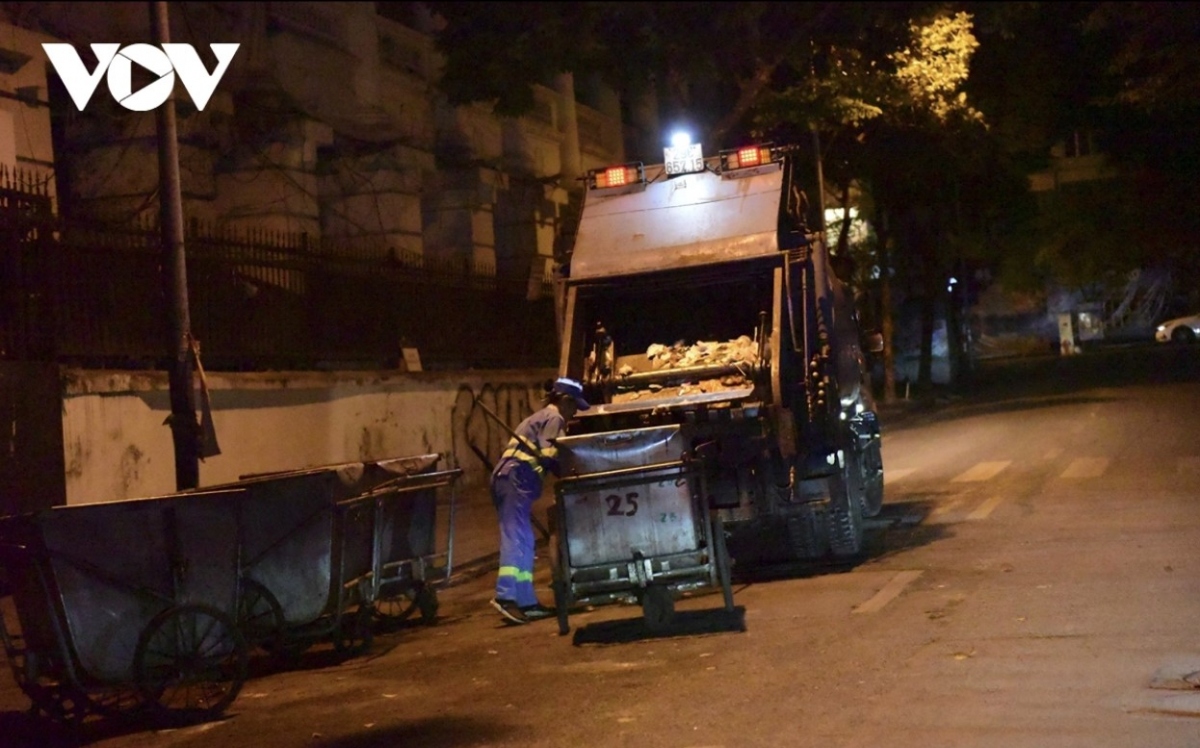 Sanitation workers struggle in the chilly coldness as they clean the road.