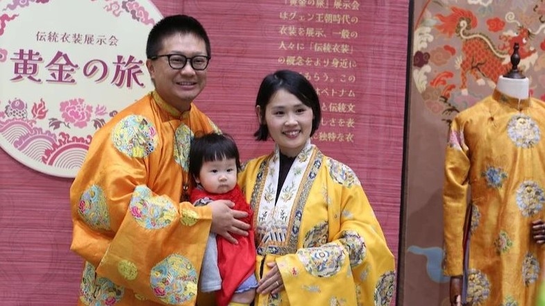 Japanese people are eager to try on traditional Vietnamese costumes and pose for a group photo.