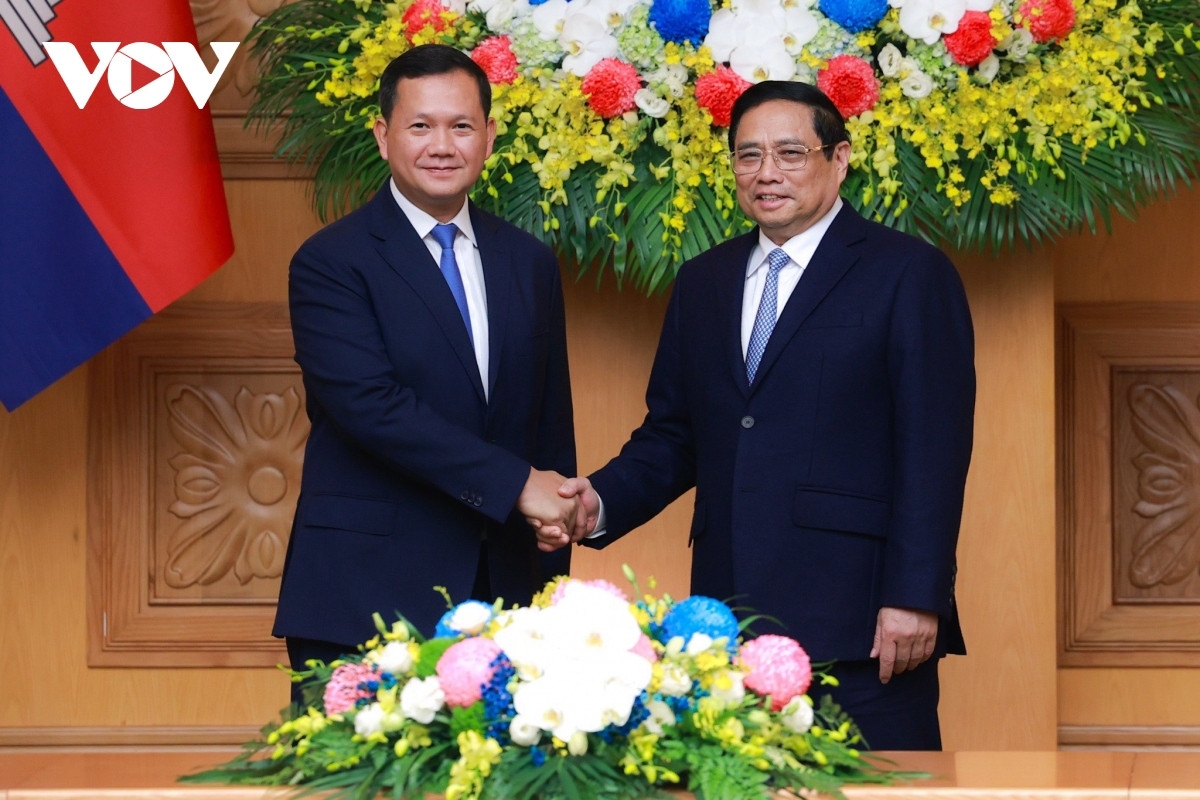 Vietnamese Prime Minister Pham Minh Chinh (R) and Cambodian Prime Minister Hun Manet shaking hands ahead of their talks in Hanoi on December 11
