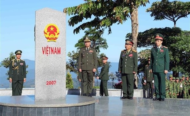 Front, from right: Minister of National Defence of Vietnam General Phan Van Giang, Deputy Prime Minister and Minister of National Defence of Laos General Chansamone Chanyalath, and Deputy Prime Minister and Minister of National Defence of Cambodia General Tea Seiha stand in front of the border marker at the border T-junction of the three countries on December 14 (Photo: VNA)