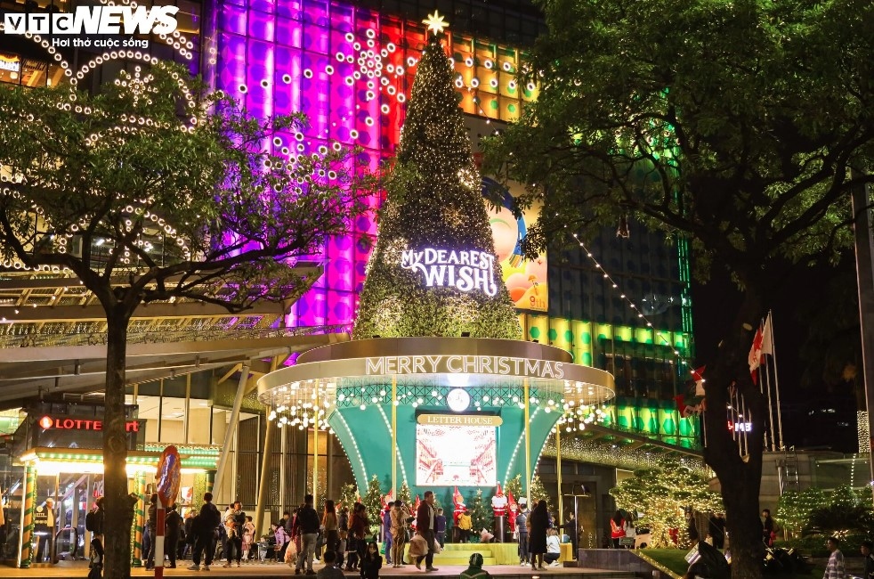 A giant Christmas tree situated in front of Lotte Centre Hanoi on Lieu Giai street features an array of LED lights, with numerous visitors keen to snap photos of the scene.