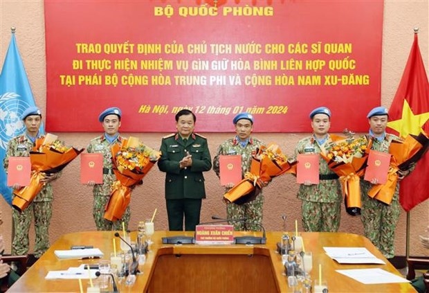 Deputy Minister of National Defence Sen. Lieut. Gen Hoang Xuan Chien presents the decision to officers 