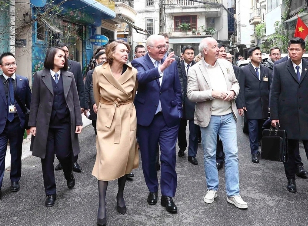 The high-ranking German delegation stroll around the small streets in Van Mieu ward of Dong Da district at midday on January 23.