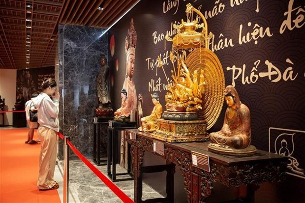 Tourist visits an ancient Buddha statue at the Buddhist Exhibition Area on the top of Ba Den Mountain.