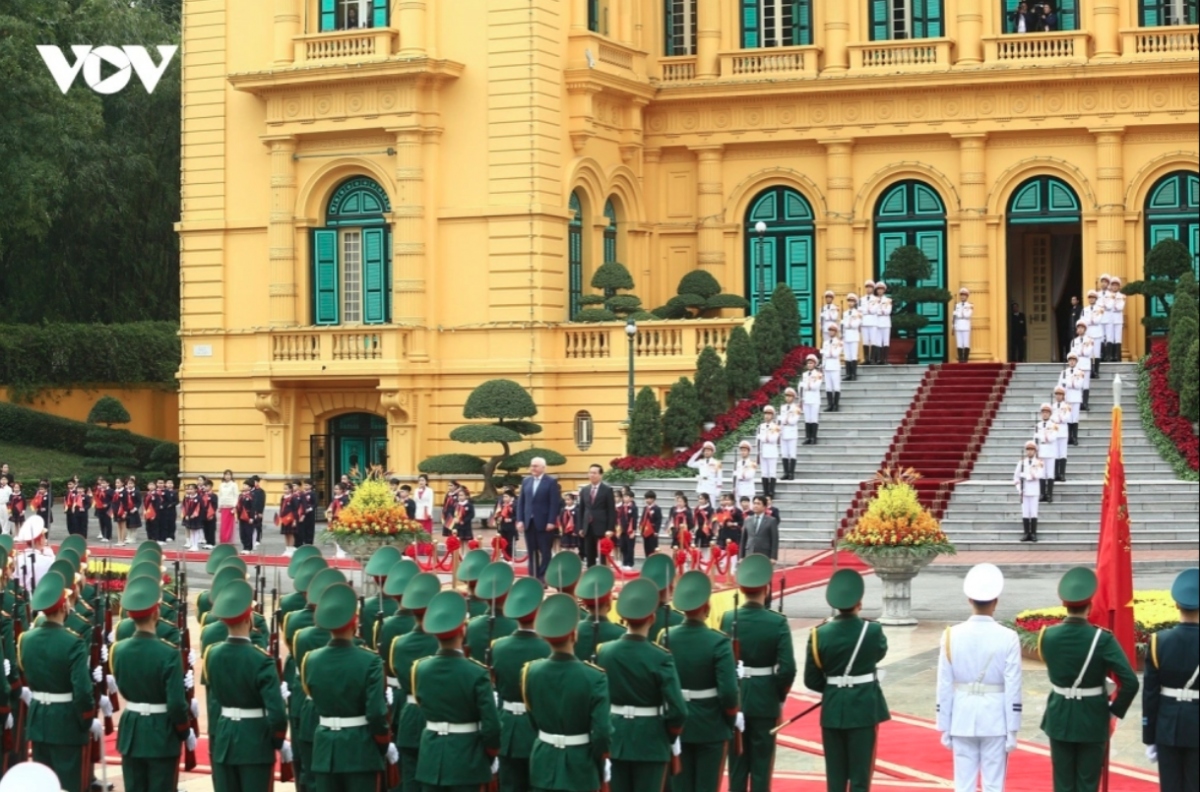 President Vo Van Thuong invites German President Frank-Walter Steinmeier to step on the podium while military bands play the national anthems of both nations.