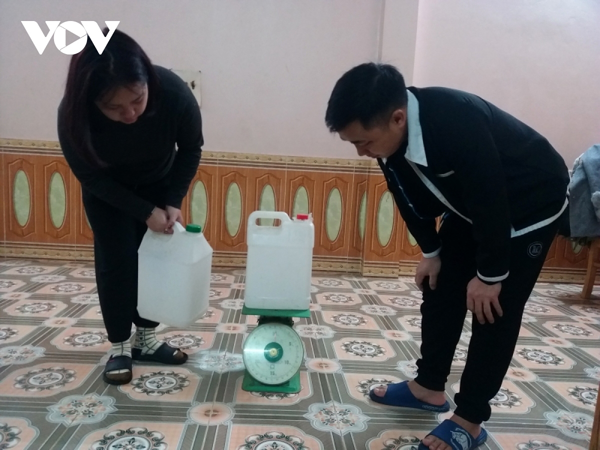Hmong people weigh two cans of water collected at the same source but at diffeent times to see what will happen in the year ahead