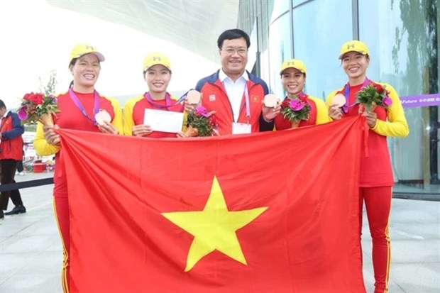 Director of the Sports Authority of Vietnam Dang Ha Viet (C) and the rowing team at the Hangzhou Asian Games 2023. The team is hoping to secure their Olympic place at the Asia-Oceania qualification in April in the Republic of Korea. 
