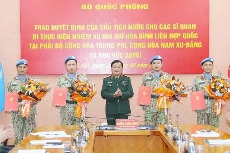 Deputy Minister of National Defence Sen. Lieut. Gen Hoang Xuan Chien (middle) presents the President's decision to four military officers (Photo: VNA)