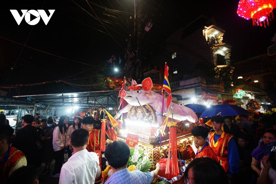 A lion dance group and a trumpet team lead the procession to the village's communal house.