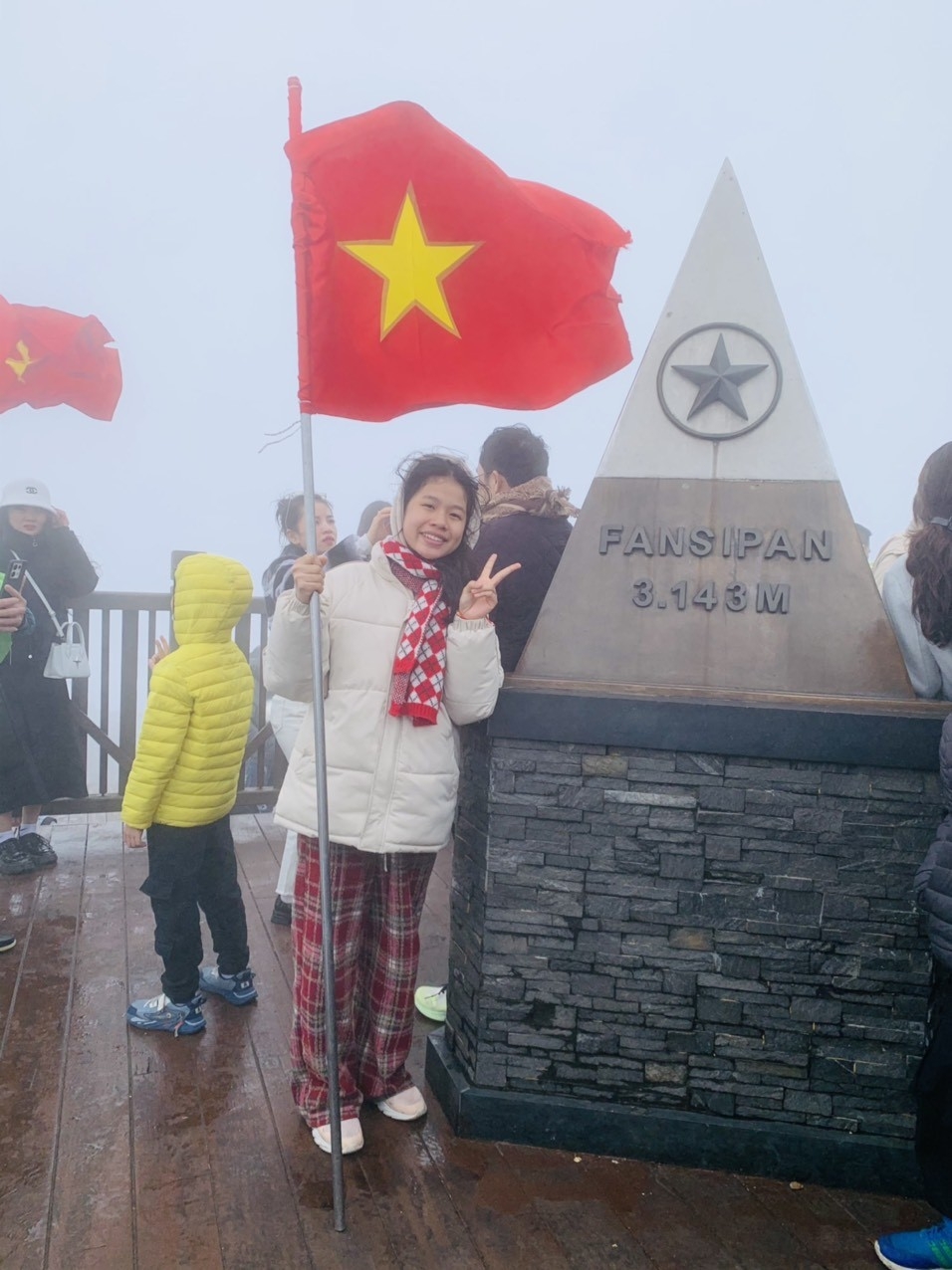 A young girl snaps a romantic photograph at the peak of Mt. Fansipan.