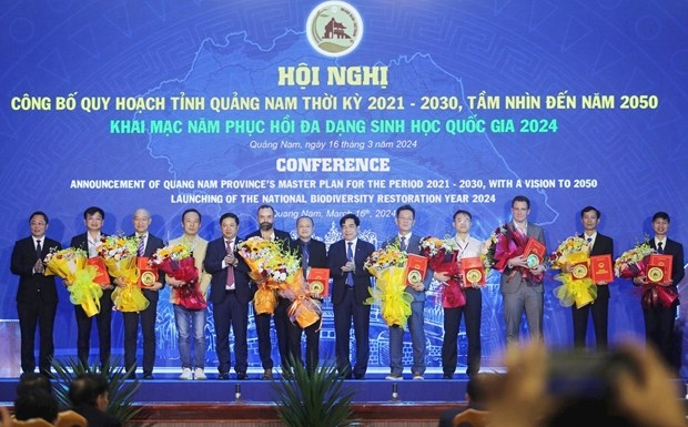 Leaders of Quang Nam province present investment policy approval decisions to businesses at the conference. (Photo: baoquangnam.vn)