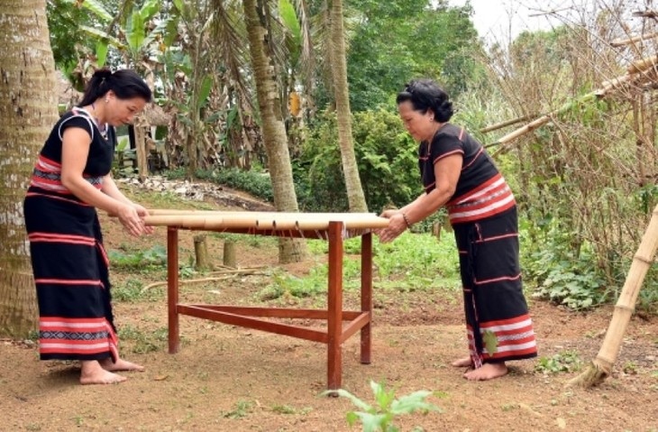 Artist Y Sinh (R) teaches a Xo Dang woman to play Klông Put. (photo: Thanh Thuan, Bao Bien phong)
