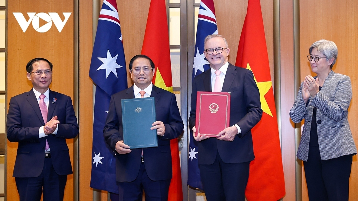 Vietnamese Prime Minister Pham Minh Chinh (second from left) and Australian Prime Minister Anthony Albanese (second from right) pose for a photo after they announce the upgrade of Vietnam - Australia relations to a comprehensive strategic partnership