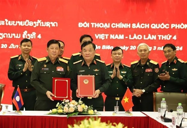 Deputy Defence Minister Sen. Lieut. Gen. Hoang Xuan Chien and his Lao counterpart Vongkham Phommakone sign the minutes of the dialogue (Photo: VNA)