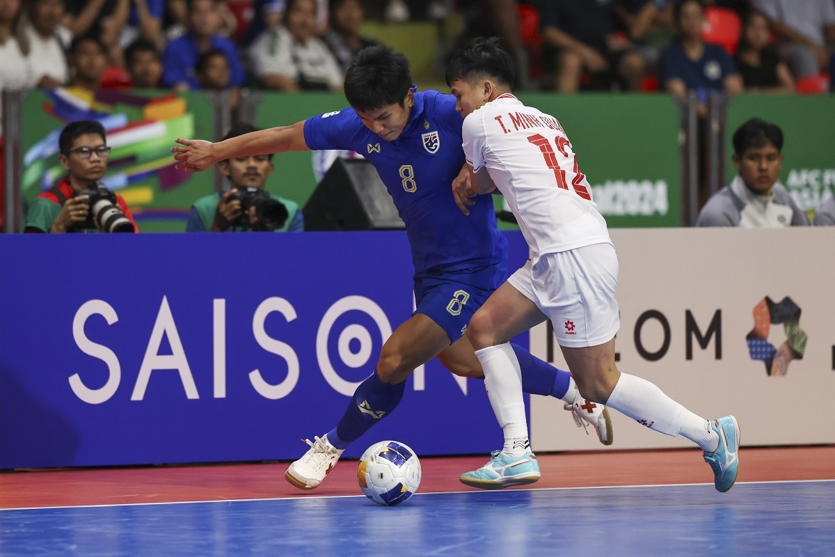 A Vietnamese player (in white jersey) and a Thai player fight for the ball. (Photo: AFC)