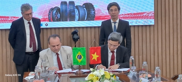 General director of Da Nang Rubber Corporation, Le Hoang Khanh Nhut (front right) and managing director of Oceanside One, Roger Zen from Brazil ink a contract for distribution of rubber tire product from Da Nang in Brazil and the US markets. (VNS Photo Cong Thanh)