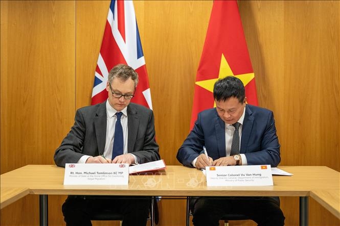 Colonel Vu Van Hung, deputy director of the Immigration Department under the Ministry of Public Security, and Michael Tomlinson, Minister of State for Countering Illegal Migration at the Home Office. sign the document in London, April 17. (Photo: VNA)