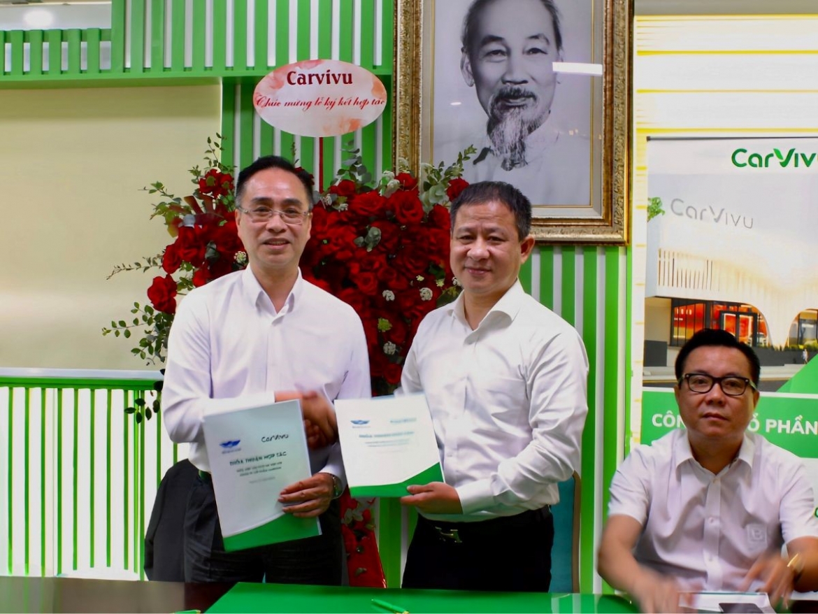 Gary Cheung (left), chairman of the Board of Carvivu, and Nguyen Cong Hung, chairman of the Hanoi Taxi Association exchange the signed agreement