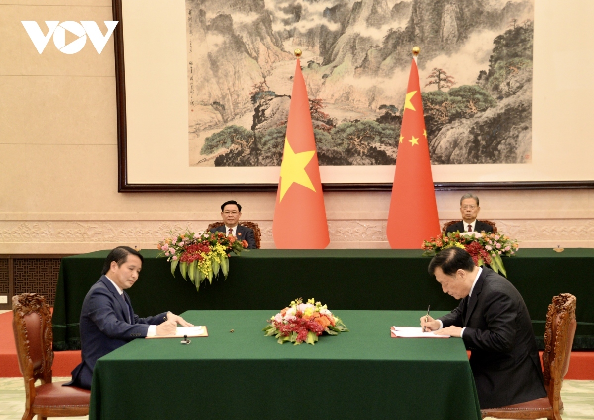 The two top legislators witness the signing of another agreement between both legislatures' offices.