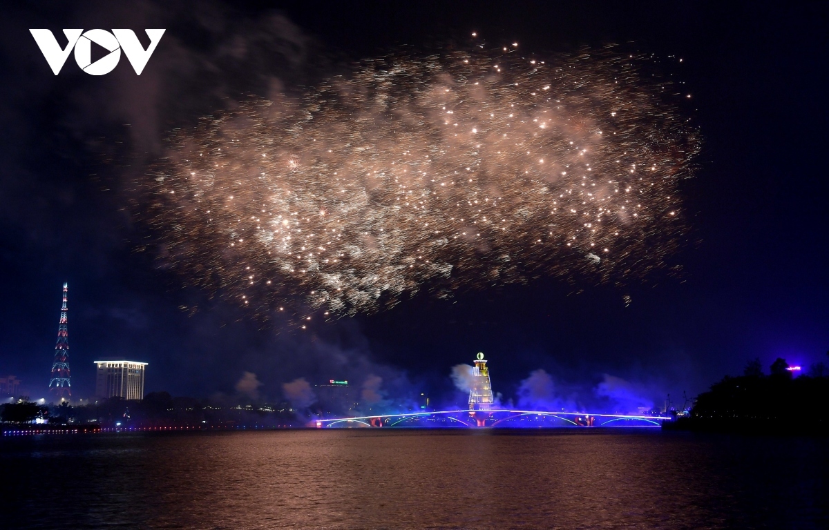 The fireworks display can be seen over the pedestrian bridge on the Van Lang Park lake.