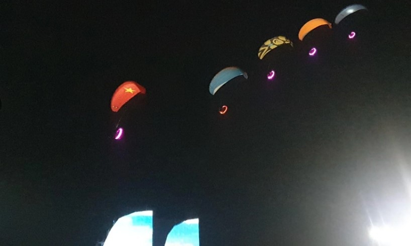 A paragliding performance excites crowds before the start of the carnival.
