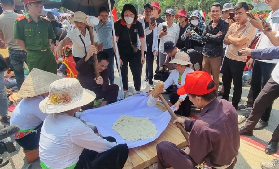 The contestants pound the sticky rice in order to make Banh Giay.