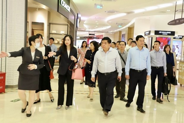 Minister of Planning and Investment Nguyen Chi Dung (C) visits the free trade centre and duty-free trade zone in Haikou.