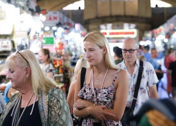 Foreign tourists visit a traditional market in Vietnam