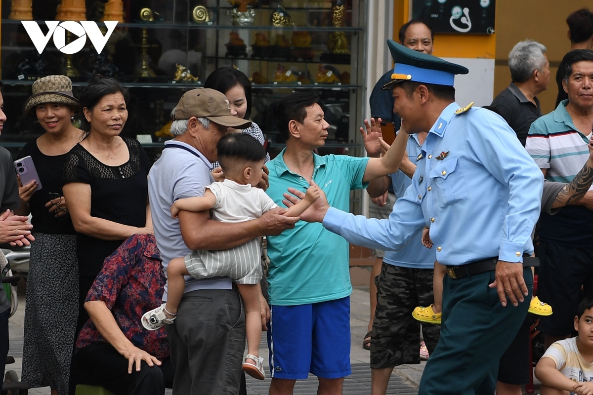 An official from the Vietnam People’s Air Force shakes hands with a child.