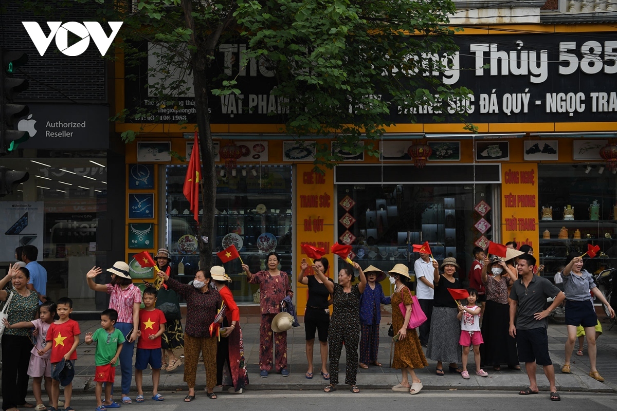 People wave national flags along Vo Nguyen Giap Street.