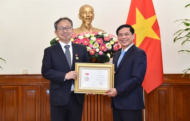 Minister of Foreign Affairs Bùi Thanh Sơn (R) presents the insignia to outgoing Japanese Ambassador to Vietnam Nam Yamada Takio  (Photo: The Ministry of Foreign Affairs) 