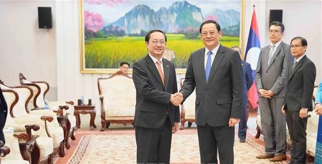 Lao Prime Minister Sonexay Siphandone (R) welcomes Vietnamese Minister of Science and Technology Huynh Tan Dat
