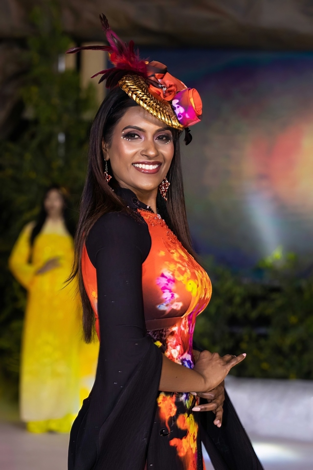 A silk outfit with a special headdress features flower patterns, getting plenty of attention from the audience.